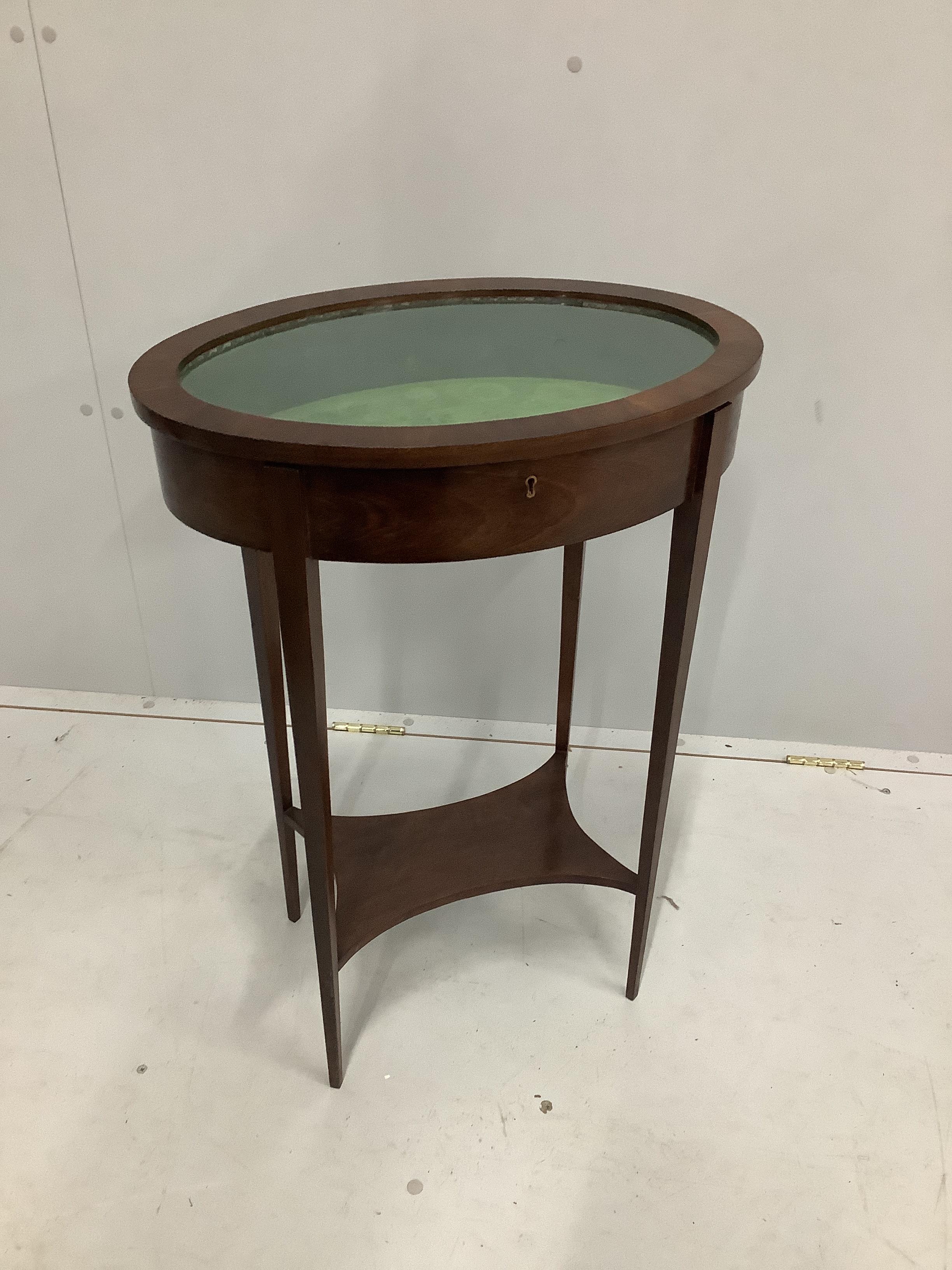 An Edwardian style oval mahogany bijouterie table, width 52cm, depth 36cm, height 75cm